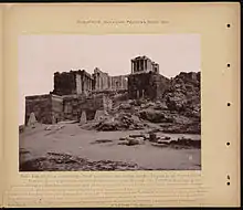 Black-and-white photograph of the gate, from a distance, showing the Temple of Athene Nike above