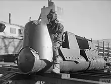 Black and white photograph of a small sea craft with a man wearing a rubber suit seated on it