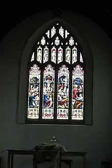 Picture of the stained glass window gifted by Hill to Axbridge parish church after its restoration in 1887. Four lights are shown representing Nativity, Crucifixion, Resurrection, and Feed my Lambs