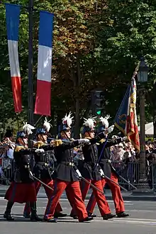 Example of dual degree with the Grande Ecole and French foremost military academy Saint Cyr, as part of which INSEEC students can complete the last year of their Grande Ecole Master's Degree curriculum, at the end of which students will earn their stripes as reserve officer, and if they wish so, can start missions as sub-officers (in French: sous-officiers). On this picture, the Colour Guard marching on the Champs-Elysées Avenue in Paris on Bastille Day.