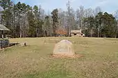 A picture of the Fort Dobbs site facing towards a log cabin that serves as the visitor's center