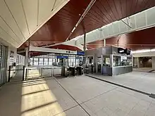 Interior of the station with ticket barriers and customer service office with lifts behind