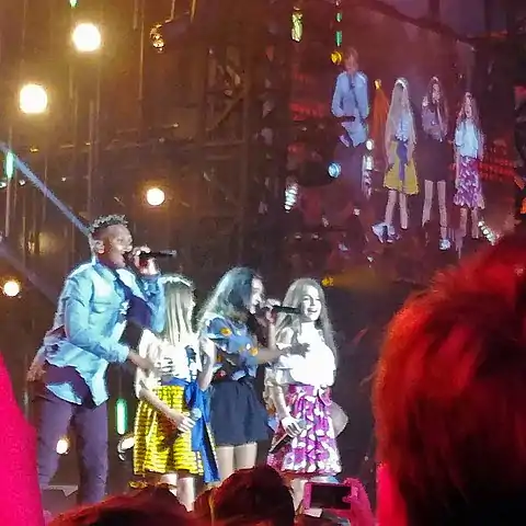 Erza (right) performing as a member of the group Kids United in July 2017.