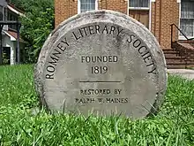 A round stone monument commemorating the establishment of the society