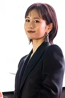 Maeda at press event wearing suit, cropped to head and shoulders portrait