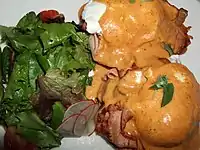 Eggs Benedict prepared with tasso ham, tomato and cajun-style hollandaise sauce