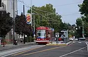The Portland Streetcar platform at Northeast 7th & Halsey with a streetcar stopped next to it.
