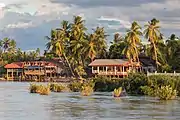 View from Don Det: river bank of the twin island Don Khon, with stilt wooden houses.