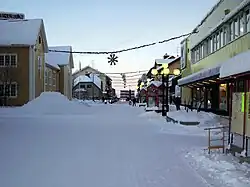 The main street (Storgatan) and December 2005 snow and Christmas lights in Gällivare at about noon.