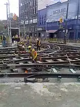 An intersection with the pavement removed, as workers repair the tracks for the Toronto streetcar system.