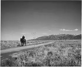 "The road to Arroyo Seco; in the distance, the Sange de Cristo Mountains, from whose melting snow comes most of the water of the area," December 1941