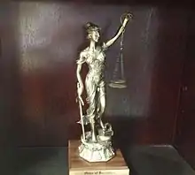 An image of a trophy awarded to a new member of the Order of Barristers. The trophy consists of a statute of Lady Justice.